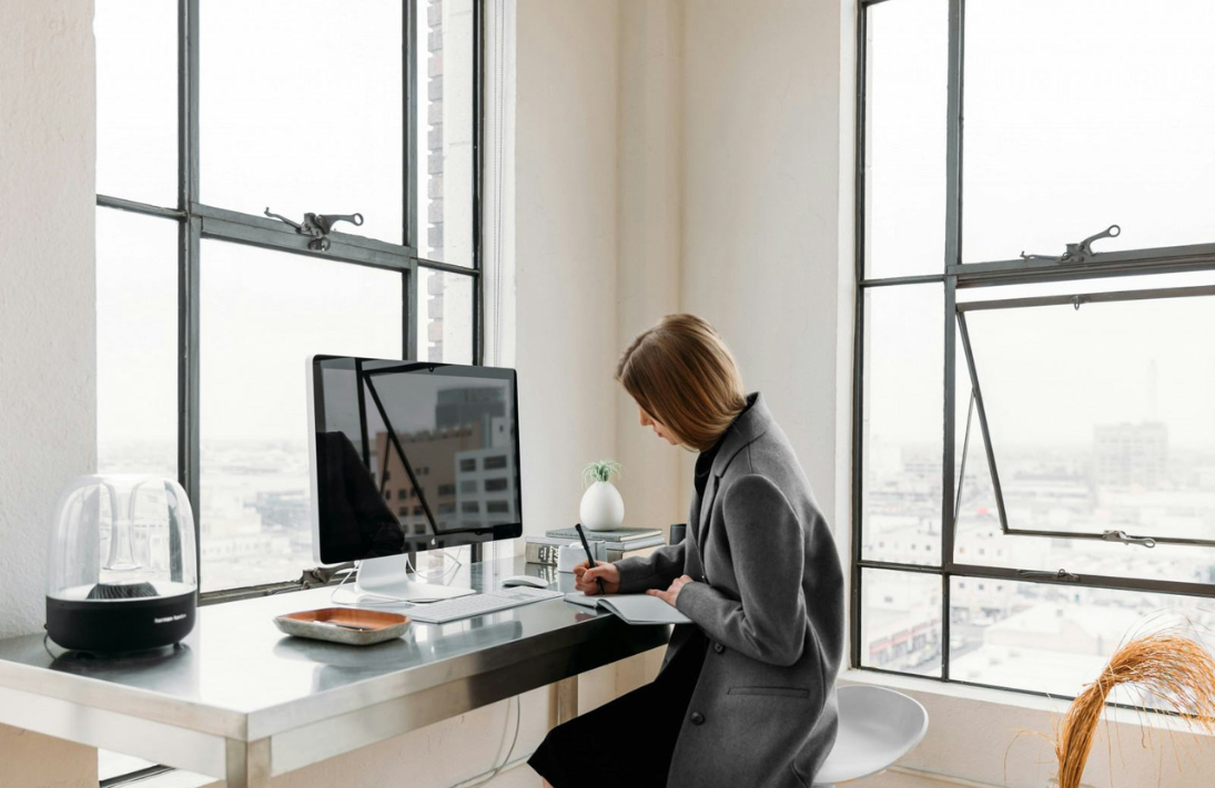 Une femme assise à son bureau travaille devant un ordinateur